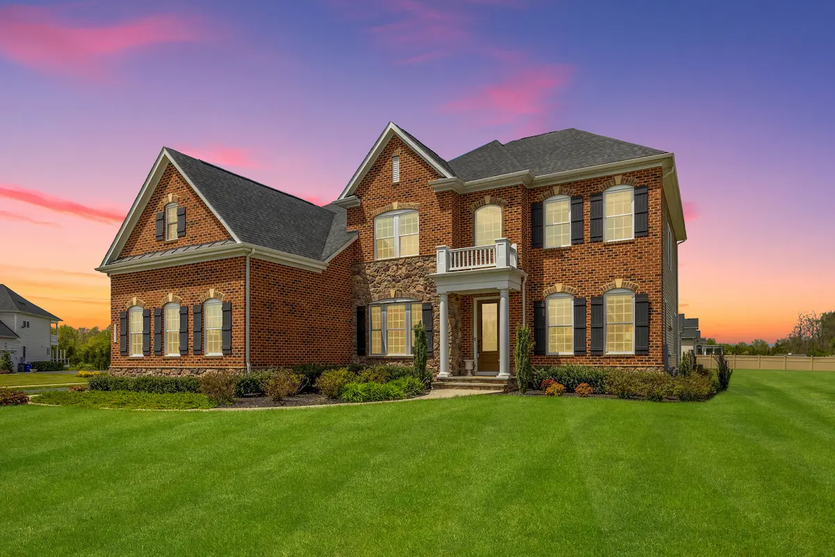 A brick colonial at dusk.